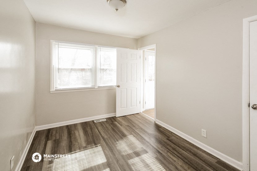 an empty room with a door and a window