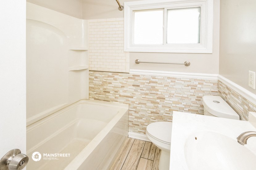 a bathroom with a tub and a sink and a toilet