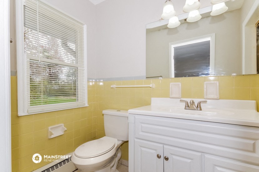 a bathroom with a toilet and a sink and a mirror