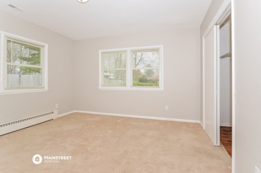 an empty room with three windows and a door
