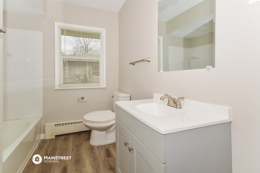 a bathroom with a sink toilet and a mirror