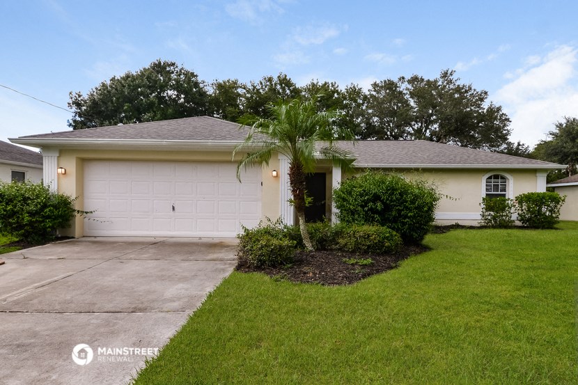 a palm tree in the front yard of a white house