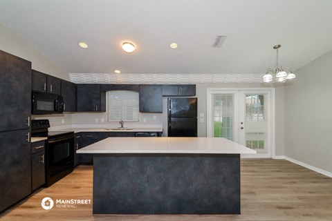 a kitchen with black cabinets and a white counter top