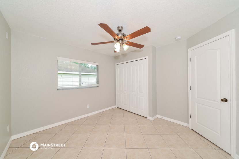 the living room has a ceiling fan and a tiled floor