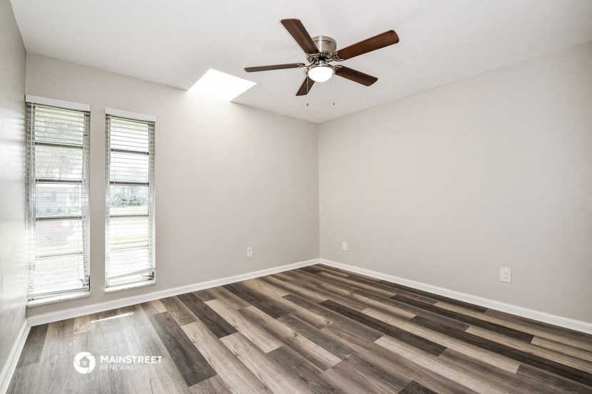 the great room with wood flooring and a ceiling fan