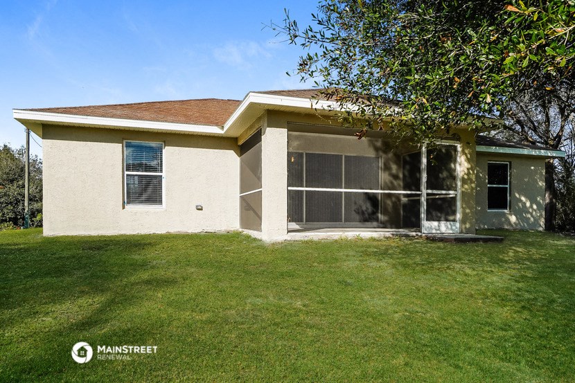 a small house with a lawn and a tree