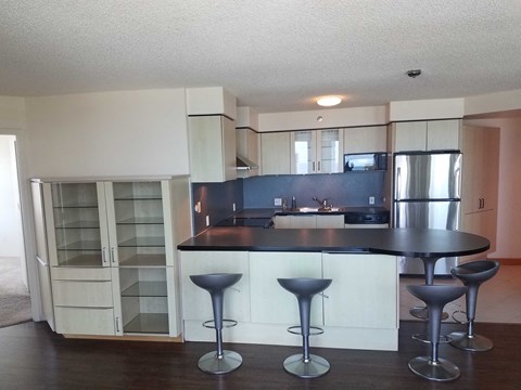 an empty kitchen with a bar and stools