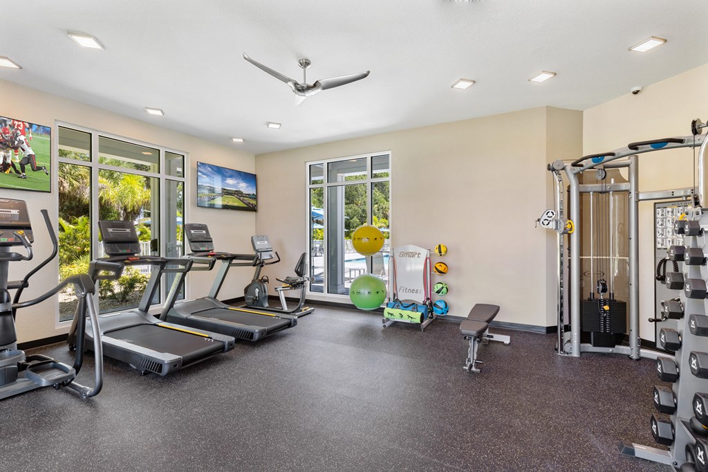 the gym with treadmills and weights at the apartments
