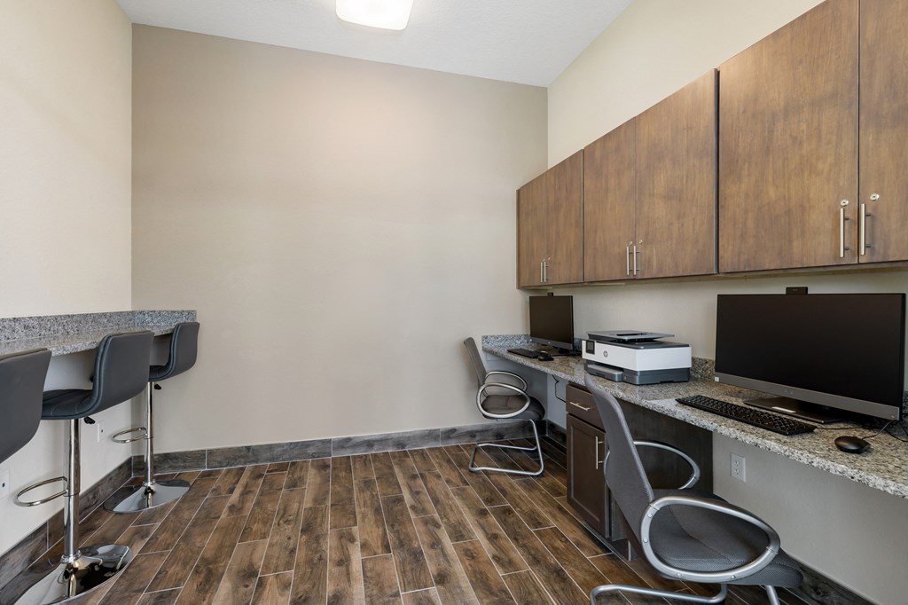 an office with a desk with a computer and a monitor