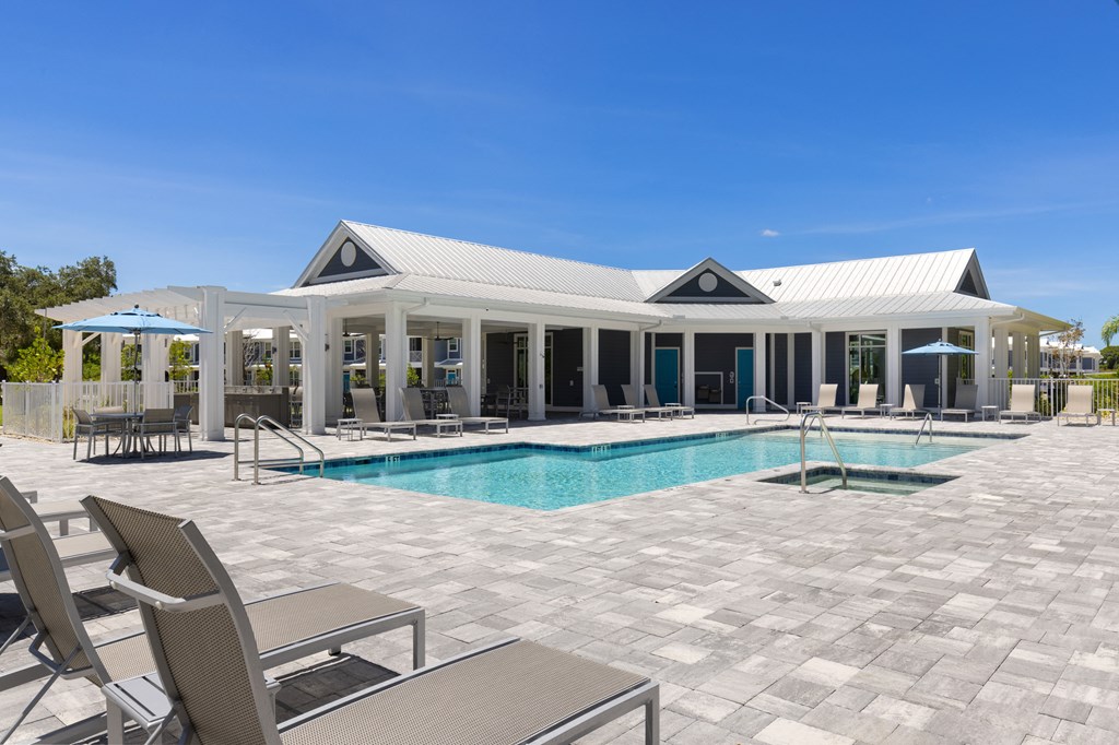 the pool and pavilion of a house with a pool and chairs