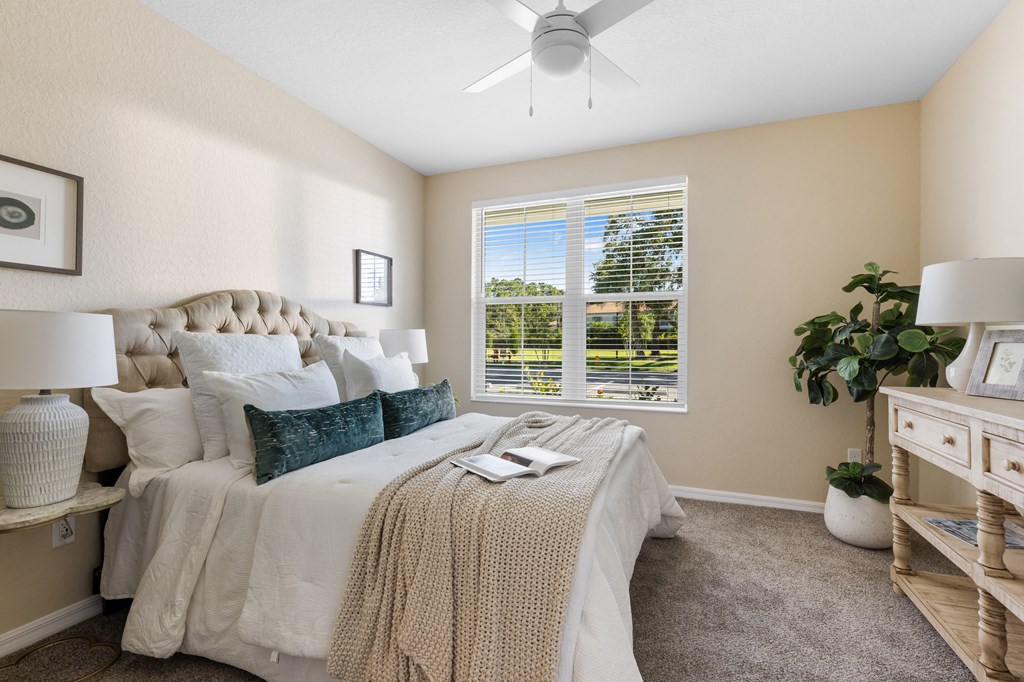 a bedroom with a large bed and a ceiling fan