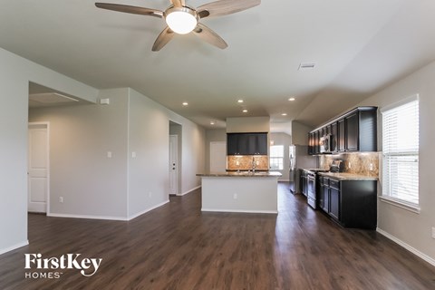 an open kitchen and living room with a ceiling fan