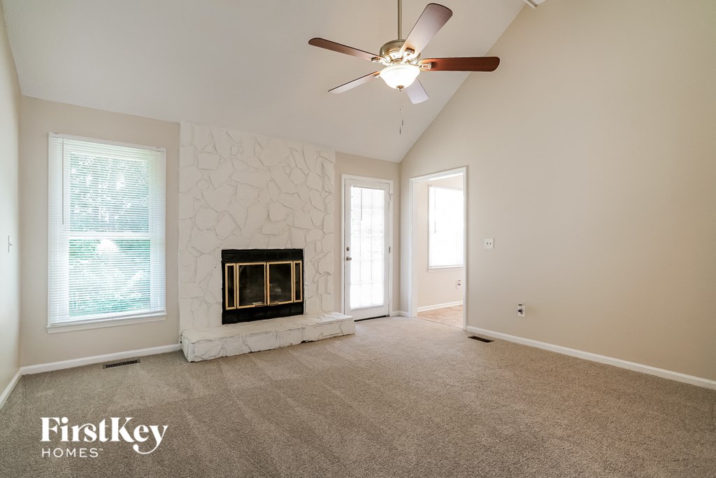 a living room with a fireplace and a ceiling fan
