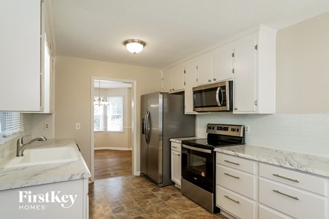 a kitchen with white cabinets and stainless steel appliances