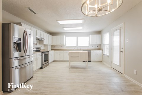 A kitchen with a refrigerator, oven, and microwave.