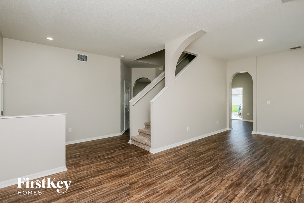 the living room and entryway with hardwood floors and white walls