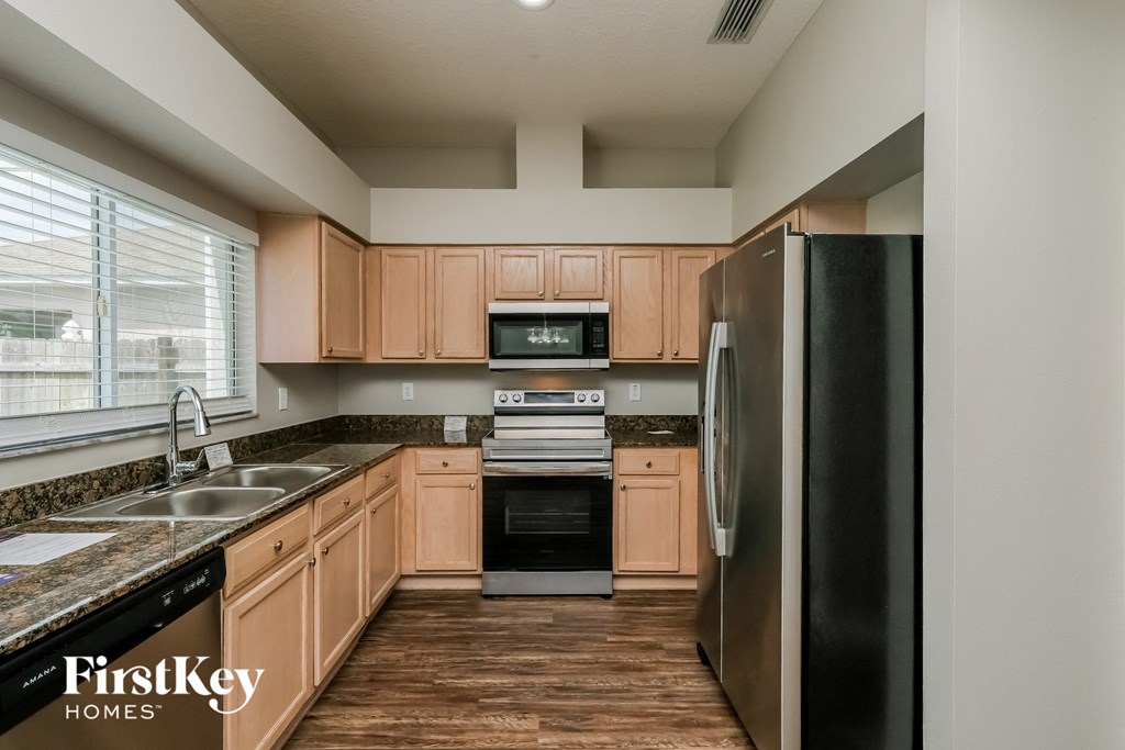 a kitchen with wooden cabinets and stainless steel appliances