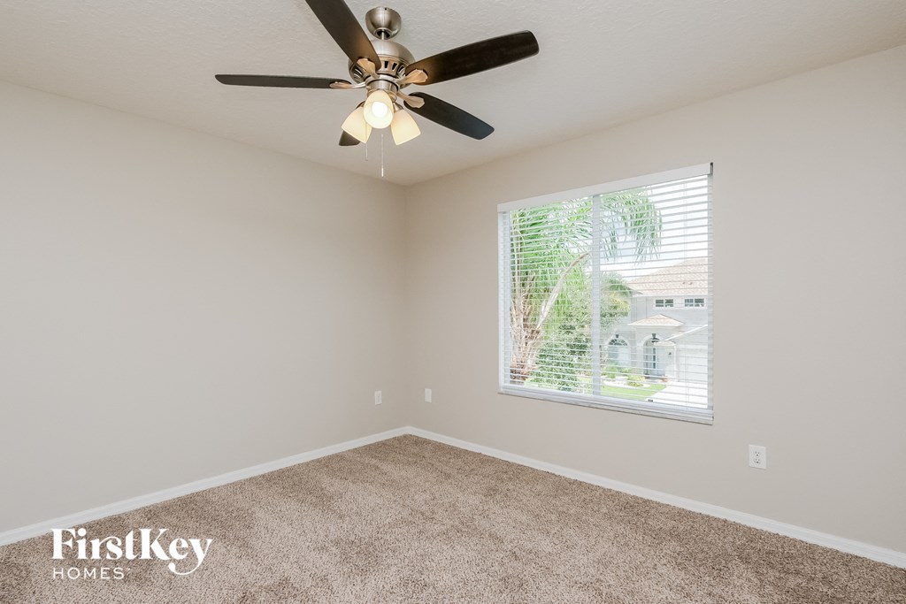 the living room has a ceiling fan and a large window