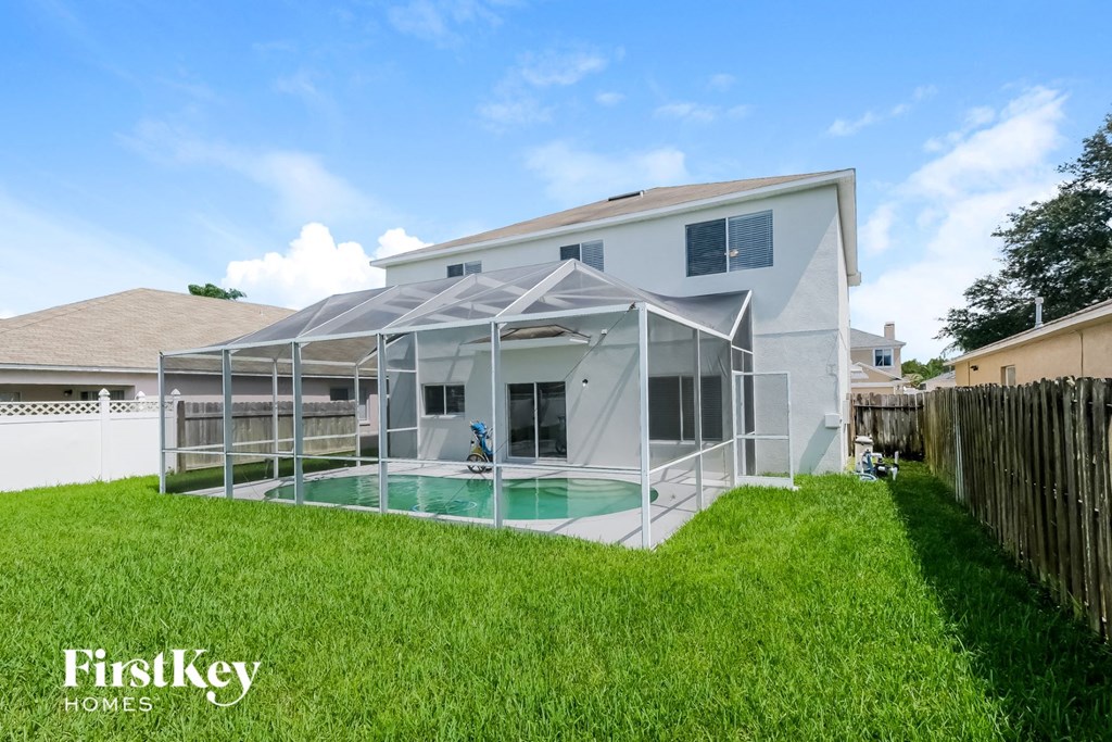 a backyard with a pool and a white house