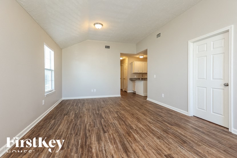 A room with wooden flooring and a white door.