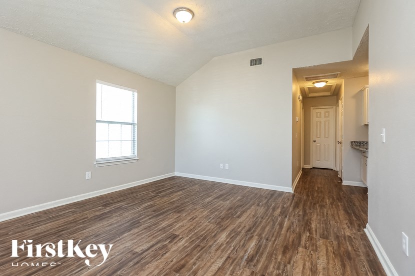 A room with wooden flooring and a window.
