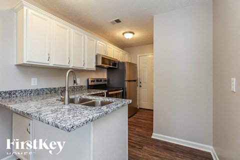 A kitchen with a granite countertop and a refrigerator.