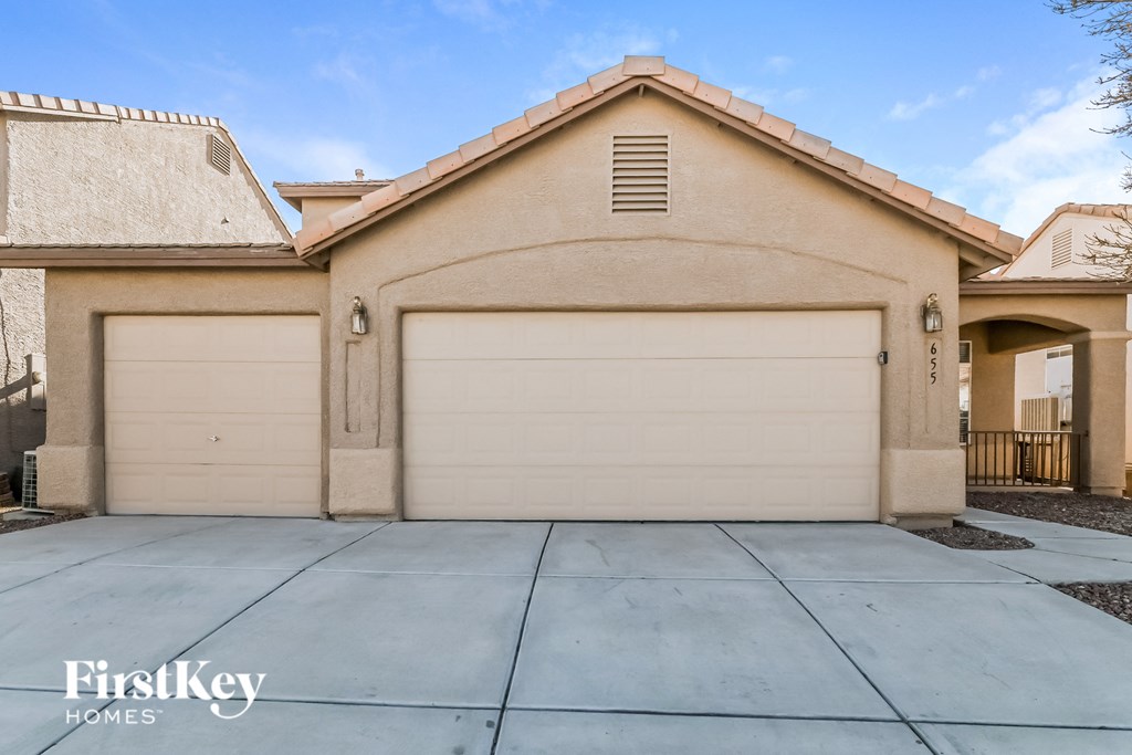 A beige house with a garage door and a logo of FirstKey Homes.