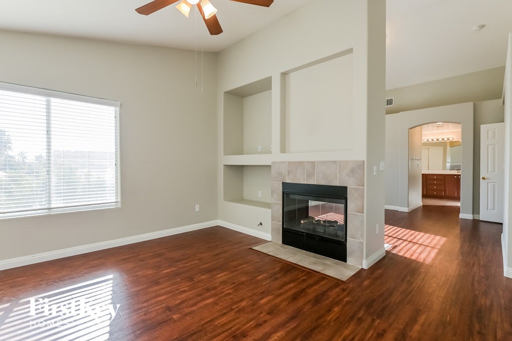 A living room with a fireplace and wood floors.