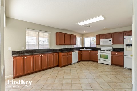 A kitchen with brown cabinets and white appliances.