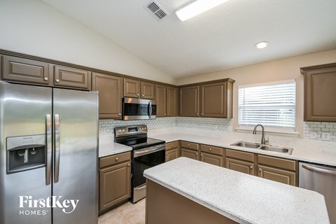 a kitchen with stainless steel appliances and white counter tops