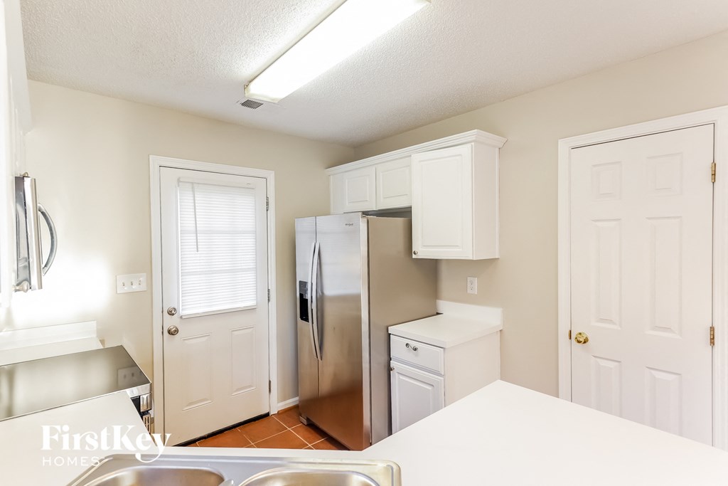 A kitchen with white cabinets and appliances.