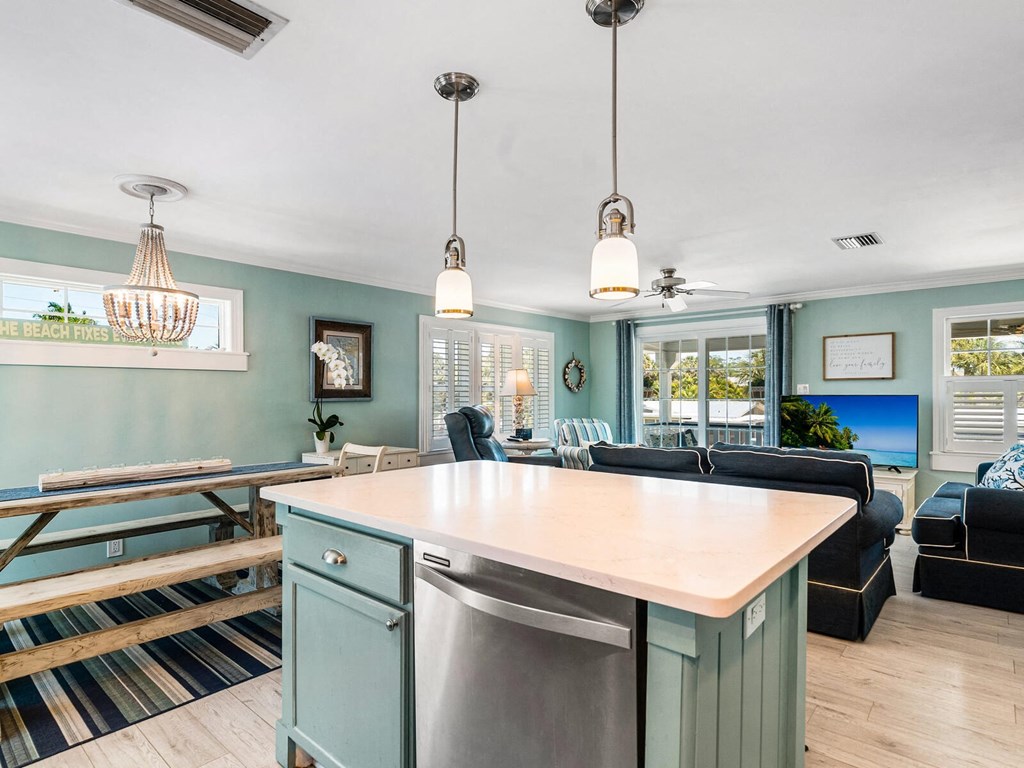 a kitchen with an island and a living room with a table and chairs