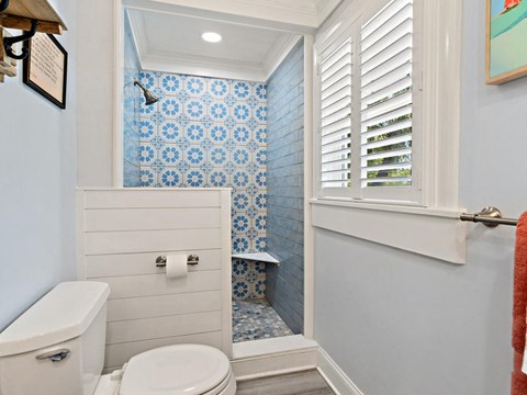 a blue and white bathroom with a toilet and shower
