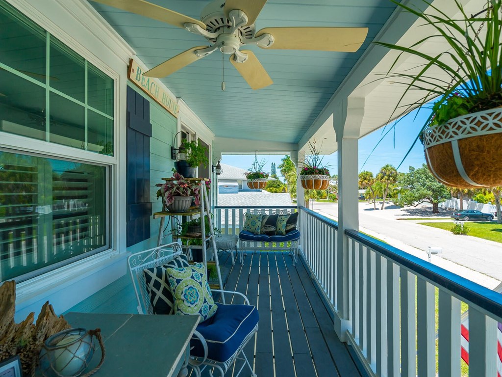 a porch with a ceiling fan and a table and chairs on it