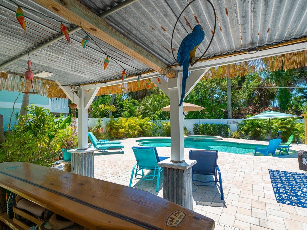 a backyard with a pool and a table and a bird on the roof