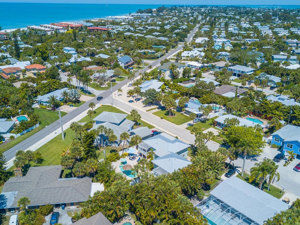 a neighborhood of houses and trees next to the beach