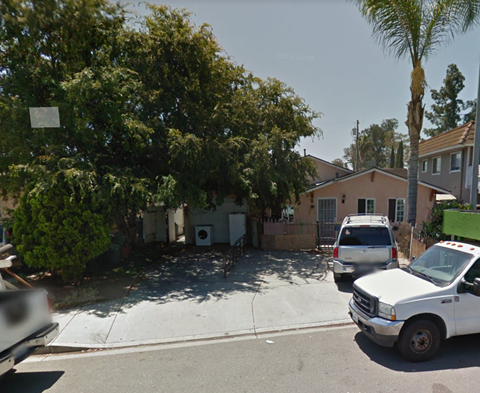 a house with a parking lot and cars in front of it