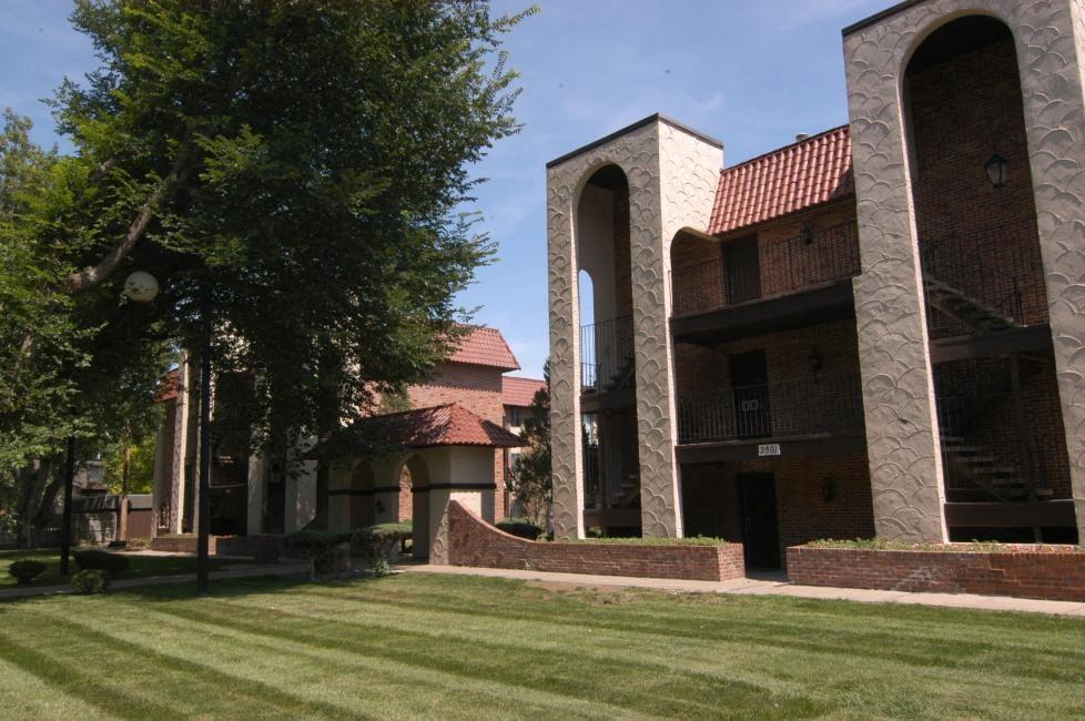 a building on the side of a green lawn