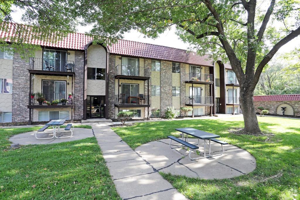 a patio with a picnic table in front of a building