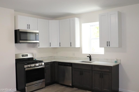 a kitchen with white cabinets and a stove and a microwave