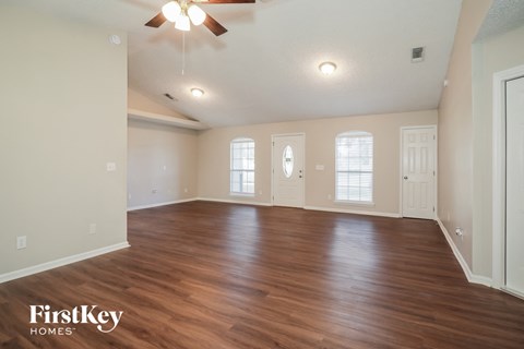 the living room with hardwood flooring and a ceiling fan
