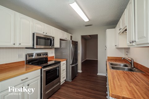 a kitchen with white cabinets and stainless steel appliances