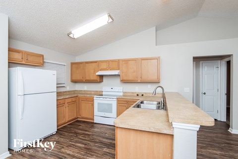 A kitchen with wooden cabinets and a white fridge.