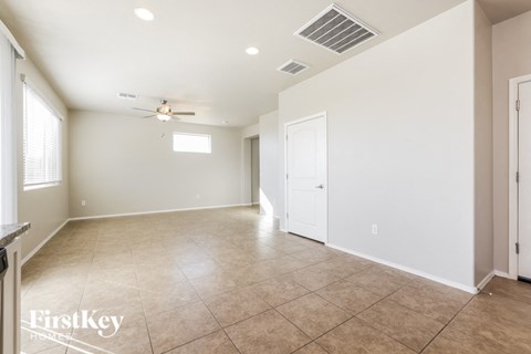 A spacious room with a ceiling fan and tile flooring.