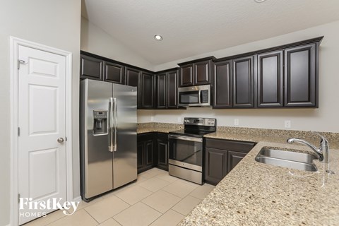 A kitchen with a granite counter top and a sink.