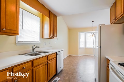 A kitchen with wooden cabinets and a white fridge.