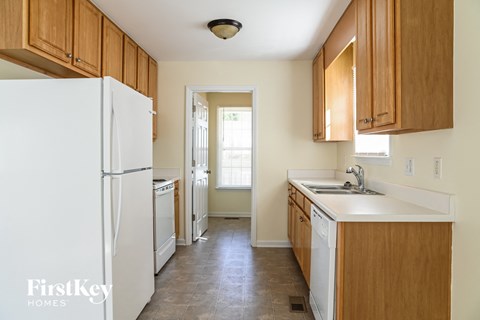 A kitchen with wooden cabinets and a white refrigerator.