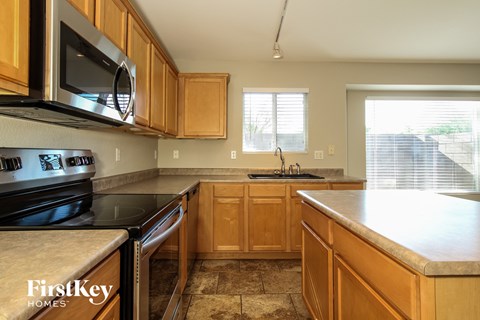 a kitchen with wood cabinets and black appliances and a sink