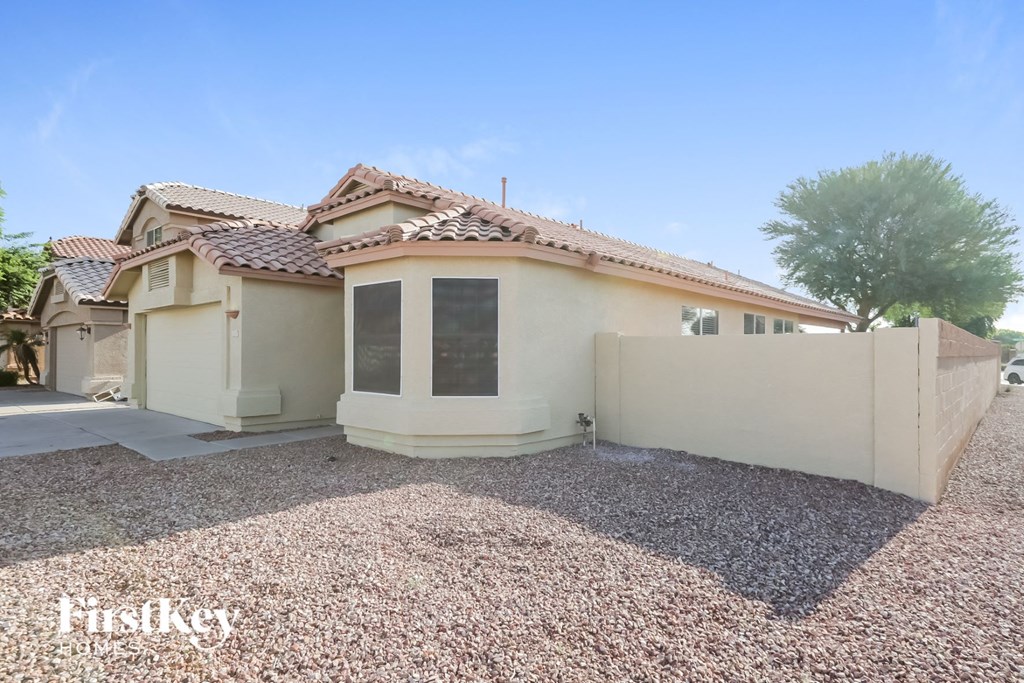 a house with a driveway and a fence in front of it