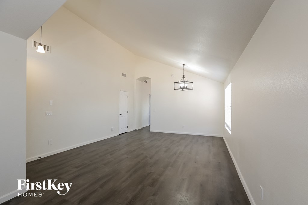 an empty living room with white walls and wood floors
